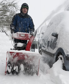 Man working with a snow blowing machine