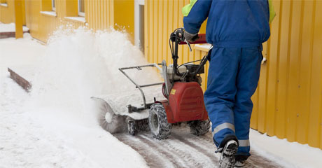 Man working with a snow blowing machine